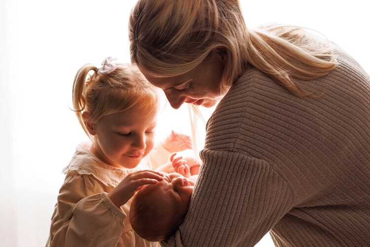 Photograph of a young family, mother, daughter and newborn baby to show family photography services with Before Time Flies.