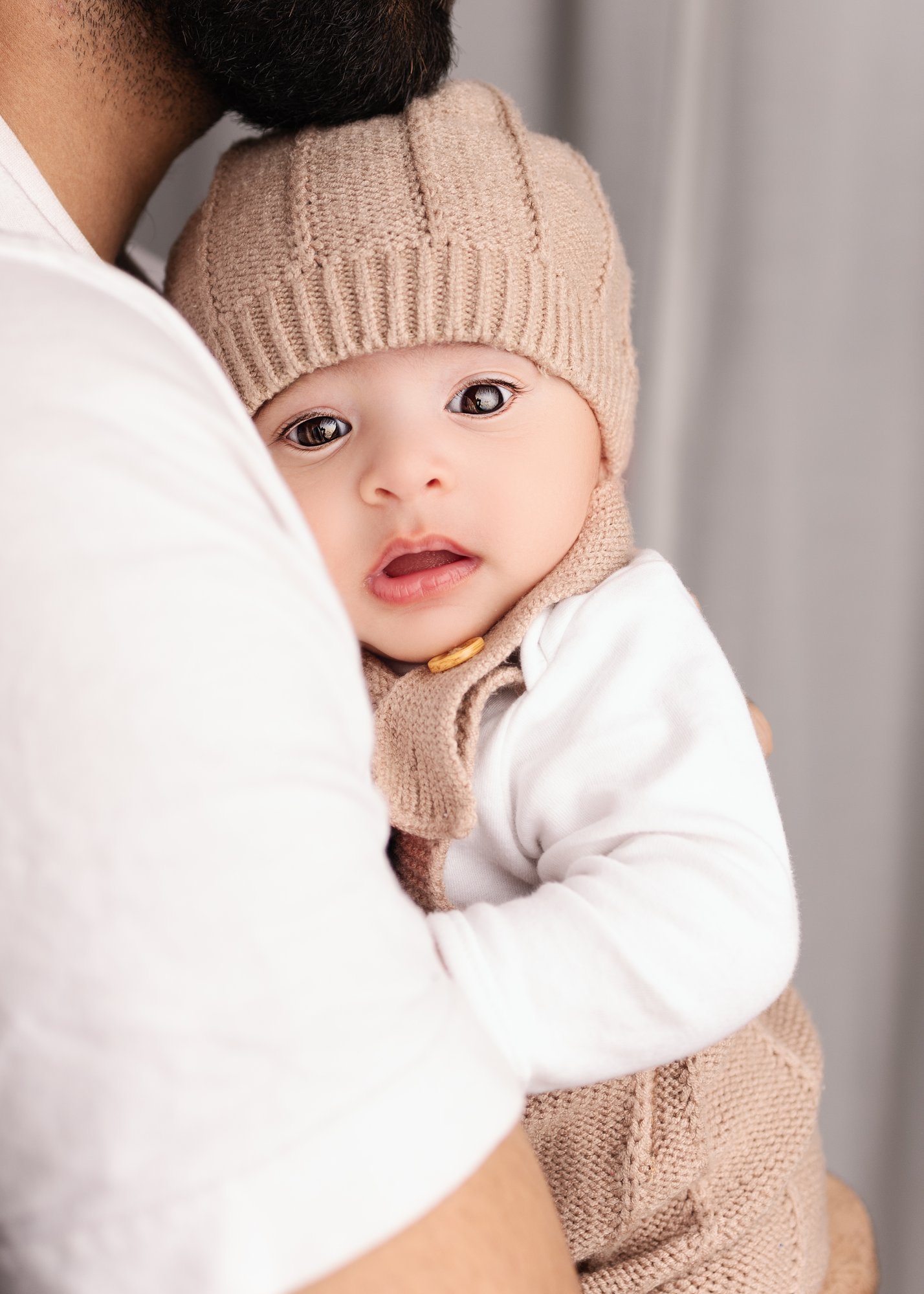 Newborn - Hat and long-sleeved top being held by Dad